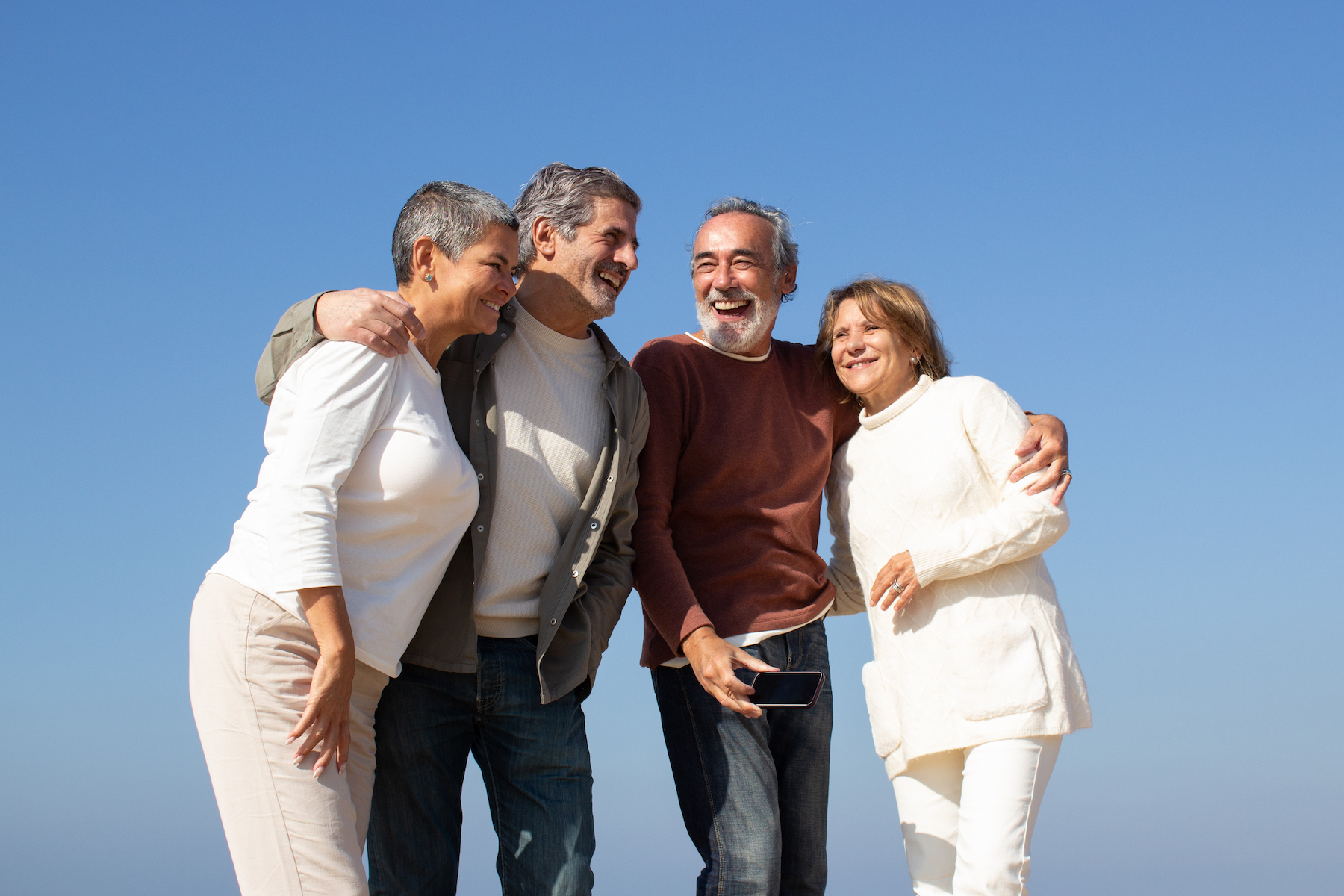 Two senior couples having fun outdoors on sunny day